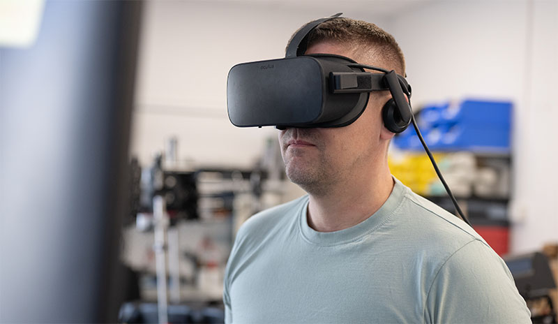 Ein Mann mit VR-Headset steht vor einem medizinischen Simulator von Mefina Medical