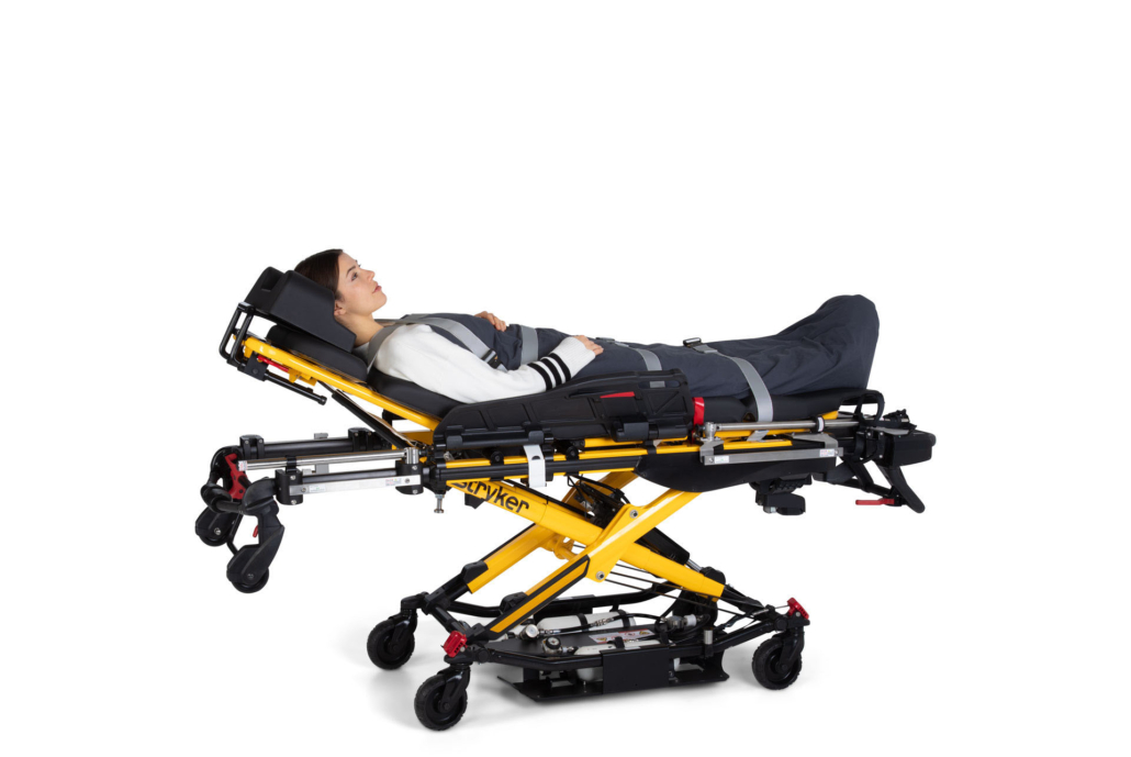 EMS-Click-an-einer-Stryker-Fahrtrage Frau liegt auf einer Stryker-Fahrtrage ausgerüstet mit EMS-Click