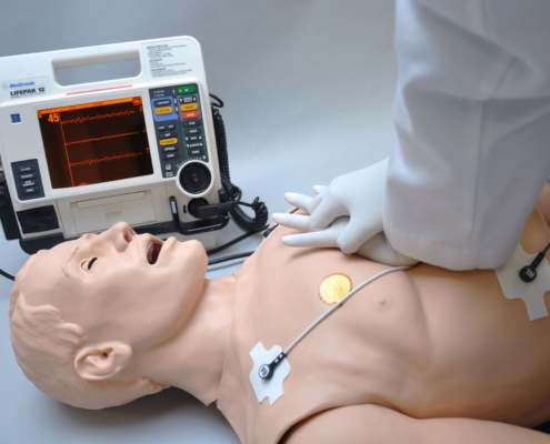 Reanimation einer Gaumard HAL S1000 - Simulationspuppe mit Patientenmonitor daneben