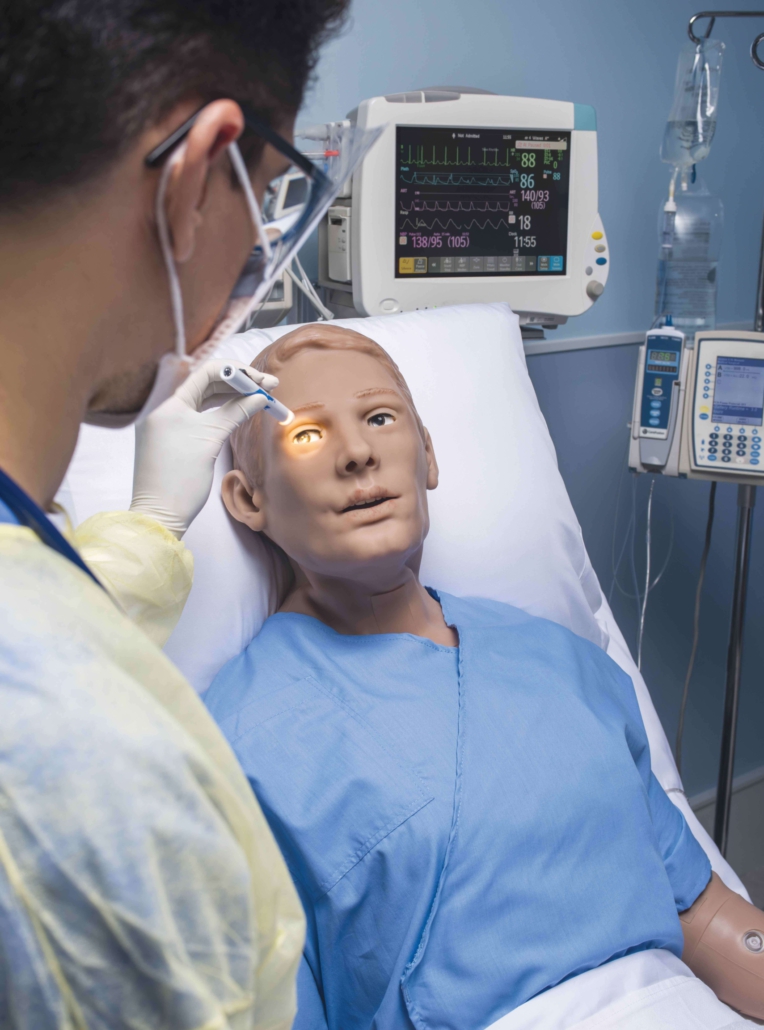 Person testet Pupillen-Reaktion des Gaumard S5301-Simulator