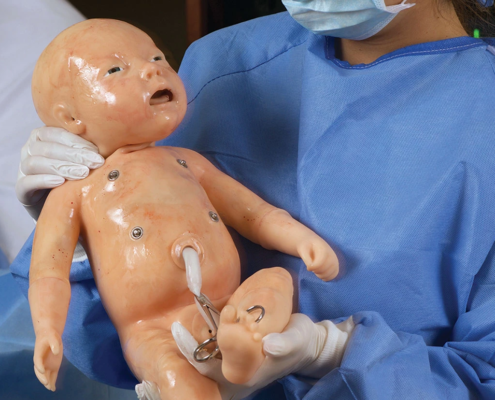 Neugeborenen Simulationspuppe im Arm einer Ärtzin