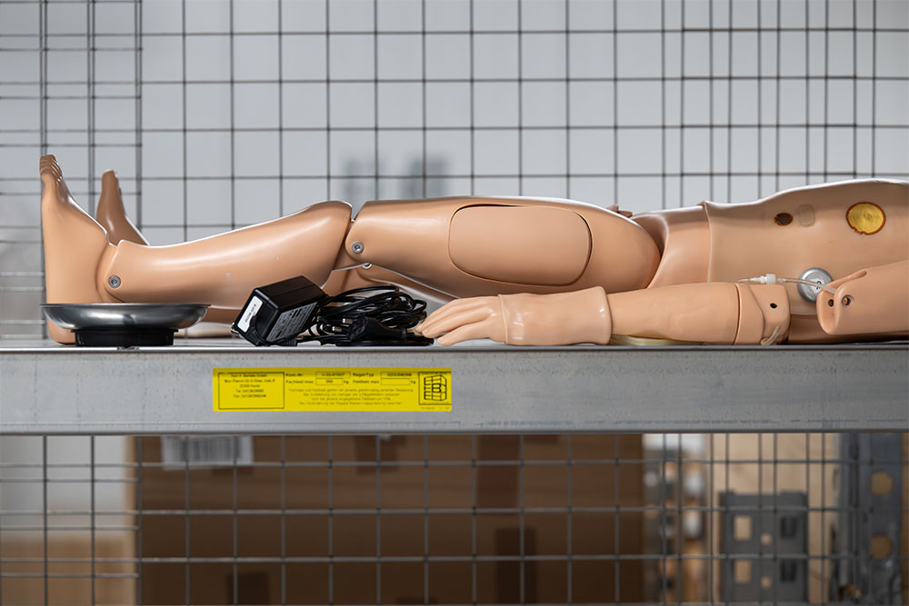 Medizinische Simulationspuppe liegt auf dem Rücken in einem Lagerregal Medizinische Simulationspuppe liegt auf dem Rücken in einem Lagerregal