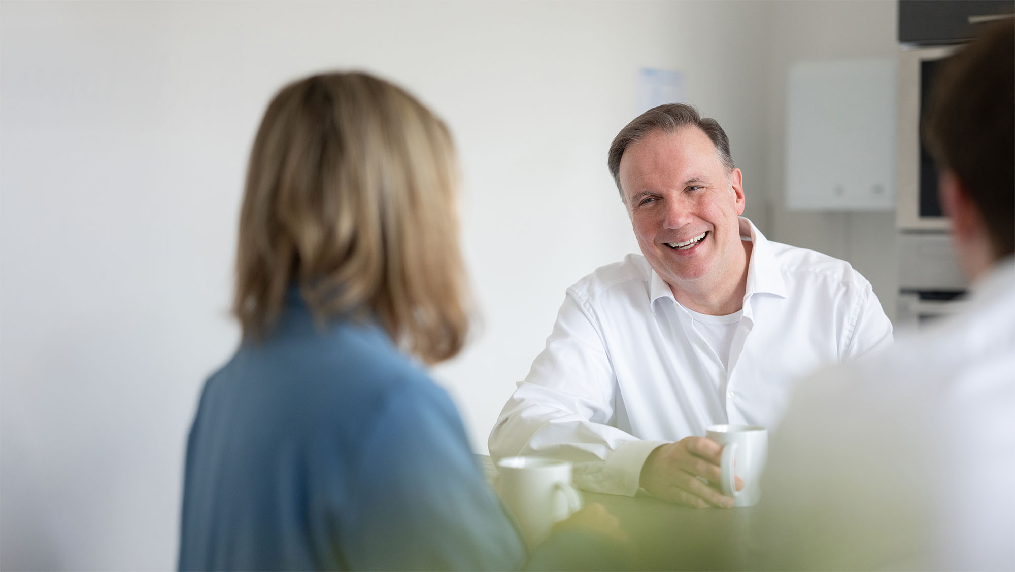 Mitarbeitende von Mefina Medical im Gespräch Mehrere Mitarbeitende von Mefina Medical im Gespräch im Pausenraum bei einer Tasse Kaffee