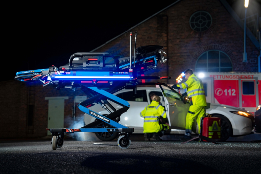 Stollenwerk-Fahrtrage-bei-Mefina-Medical-nachts-beleuchtet Rettungseinsatz im Hintergrund mit Stellwerk Fahrtrage im Fokus