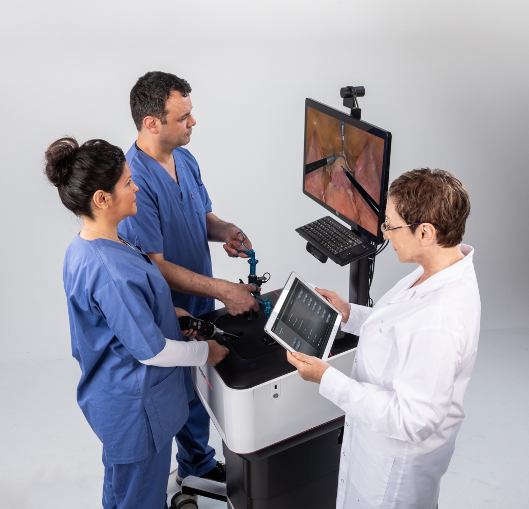 surgical-science-lap-mentor-drei-personen-trainieren Drei Personen trainieren medizinischen Eingriff an Laparoskopie-Simulator