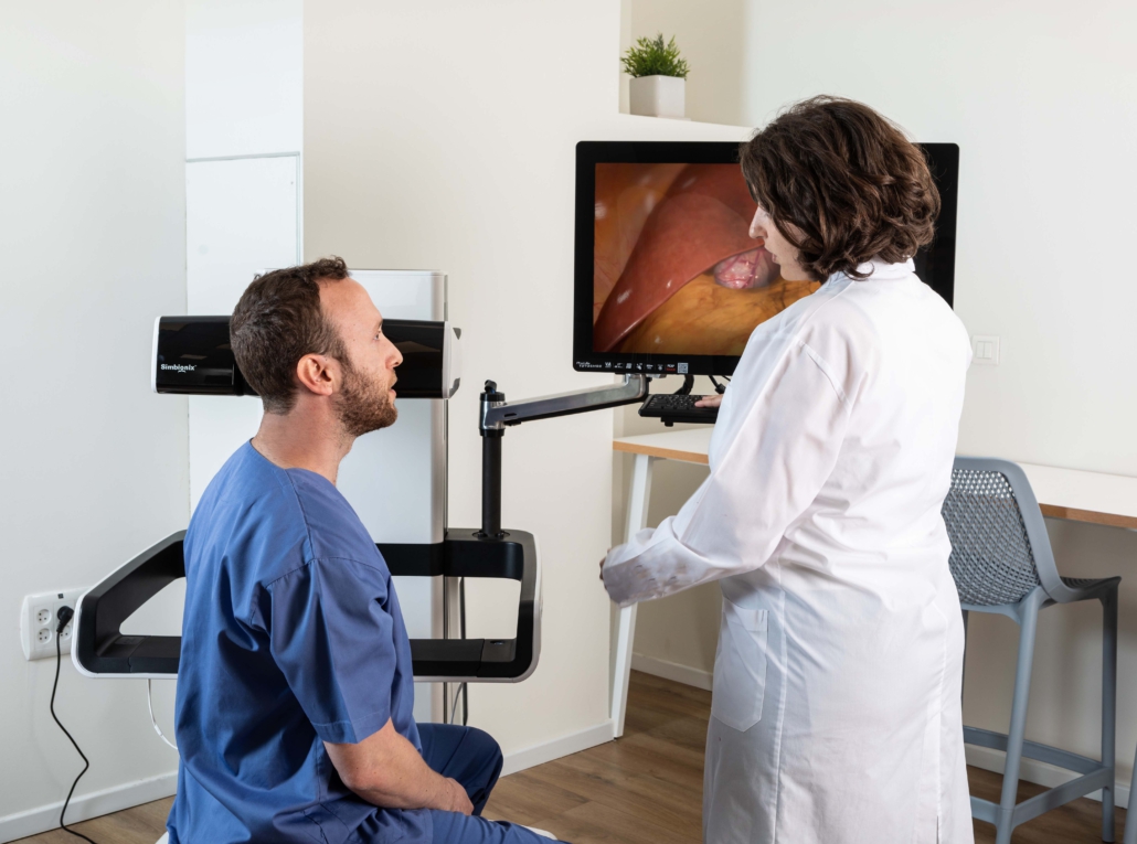 zwei Personen im Gespräch und dem High-Fidelity-Simulator im Hintergrund