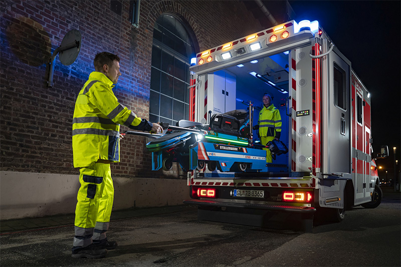 Stollenwerk-Szenenbild-bei-Nacht CPS-Fahrtrage von Stollenwerk wird von Rettungssanitäter in Rettungswagen eingeladen