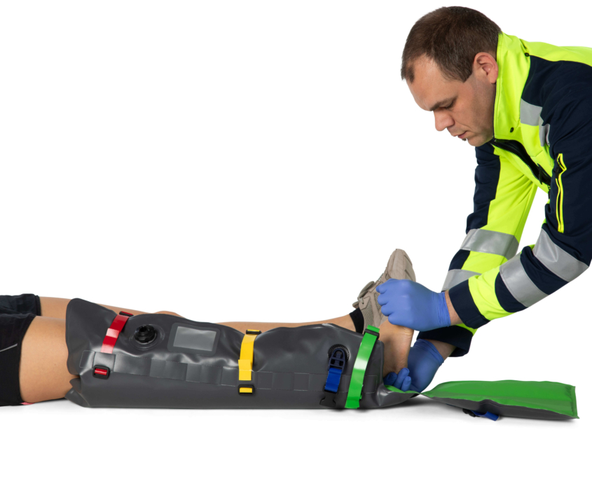 Rettungssanitäter bringt Mefina EMS-Vac Splints Beinschiene an rechtem Bein einer Patientin an