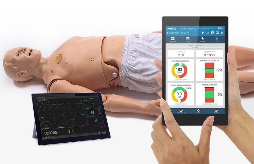 Patientensimulator von Gaumard im Hintergrund mit Fokus auf Tablet und OMNI 2 Anzeigebildschirm im vorderen Bildabschnitt